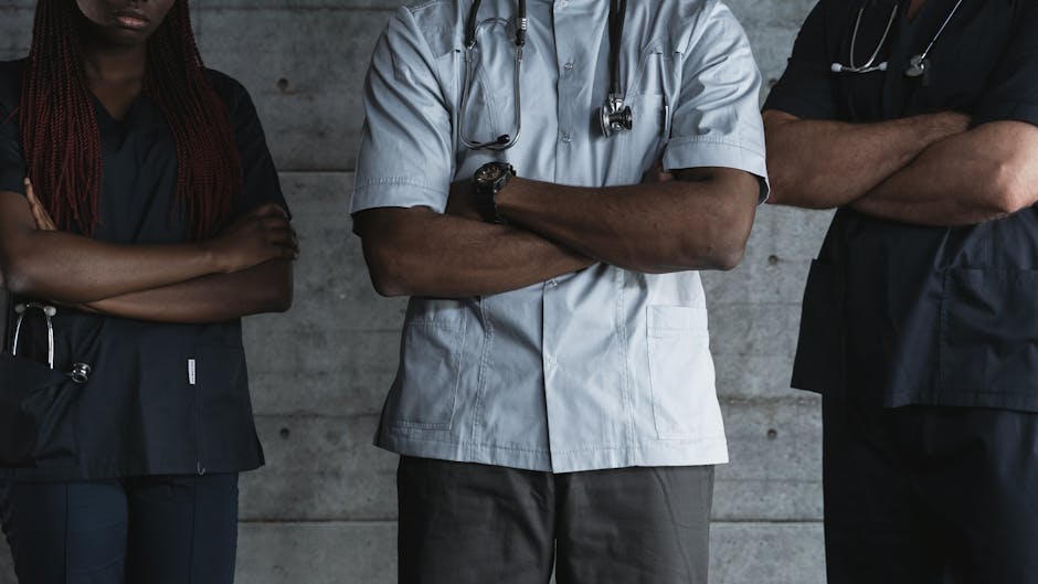 Group of medical professionals standing confidently with folded arms in uniform